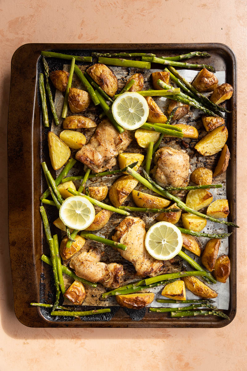 Lemon chicken sheet pan meal with slices of lemon on top.