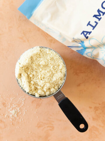 A measuring cup filled with almond flour.