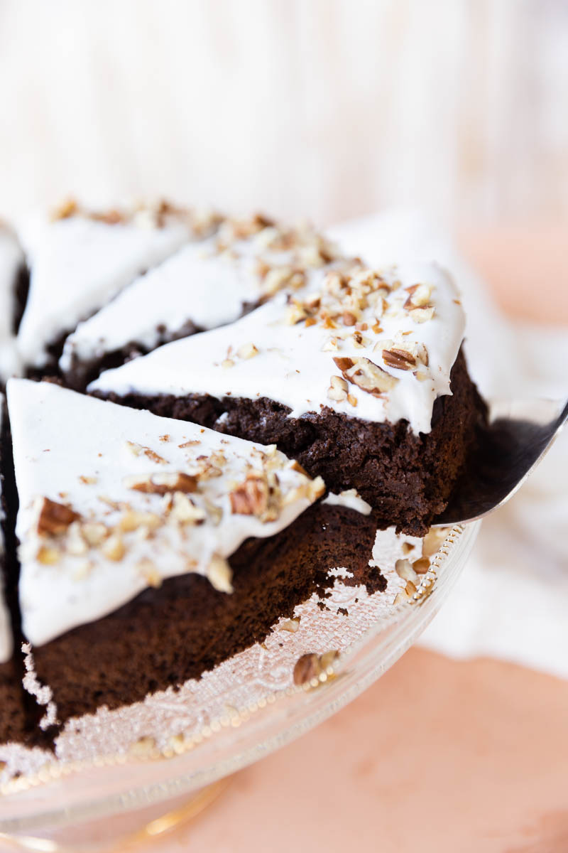 Serving tool picking up a slice of chocolate carrot cake.