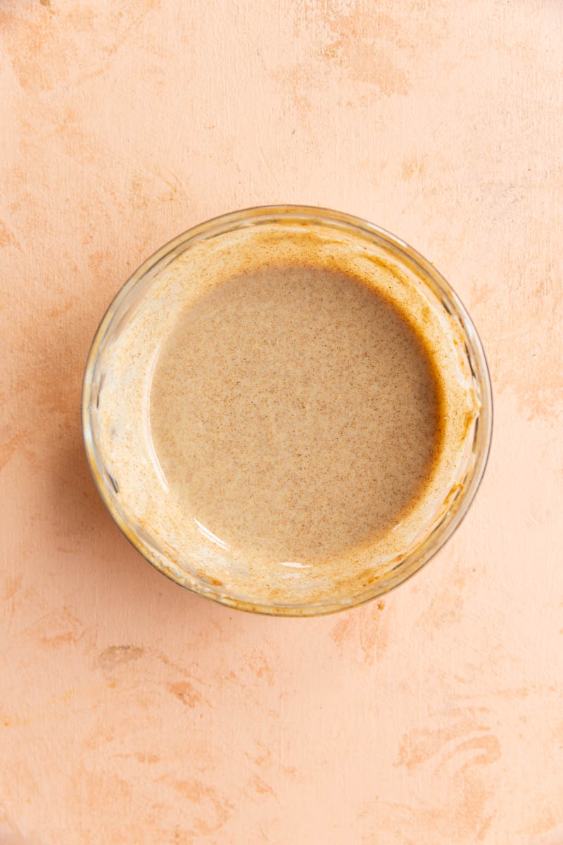 Creamy cinnamon salad dressing in a glass bowl.