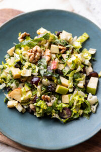 Fruit and nut salad on a blue plate.