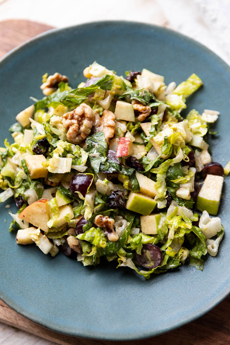 Fruit and nut salad on a blue plate.
