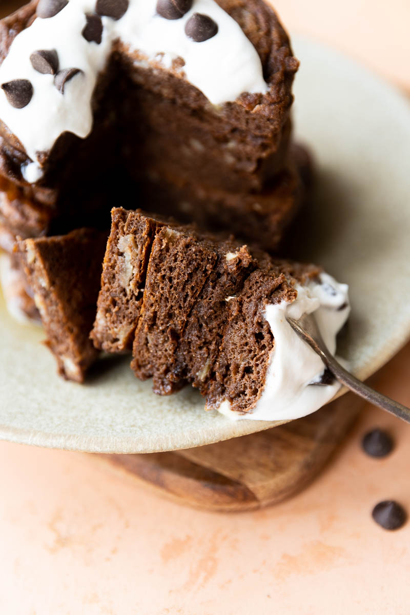 A large bite of chocolate pancakes on a fork.