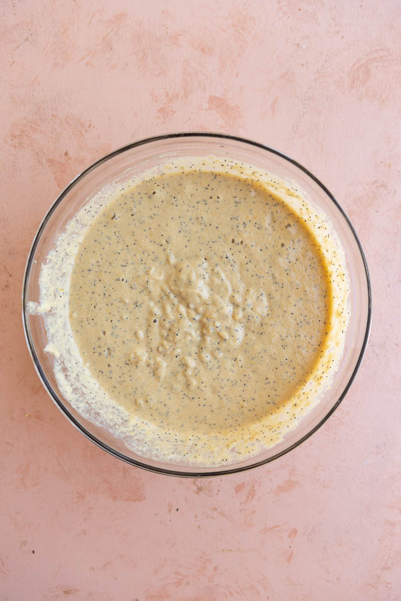 Lemon poppyseed cupcake batter in a glass bowl.