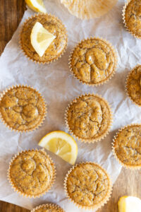 Lemon poppyseed cupcakes on a parchment paper lined board.