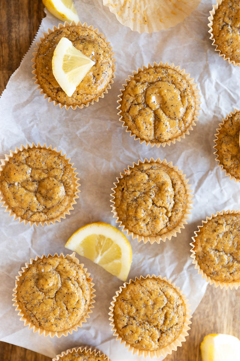 Lemon poppyseed cupcakes on a parchment paper lined board.
