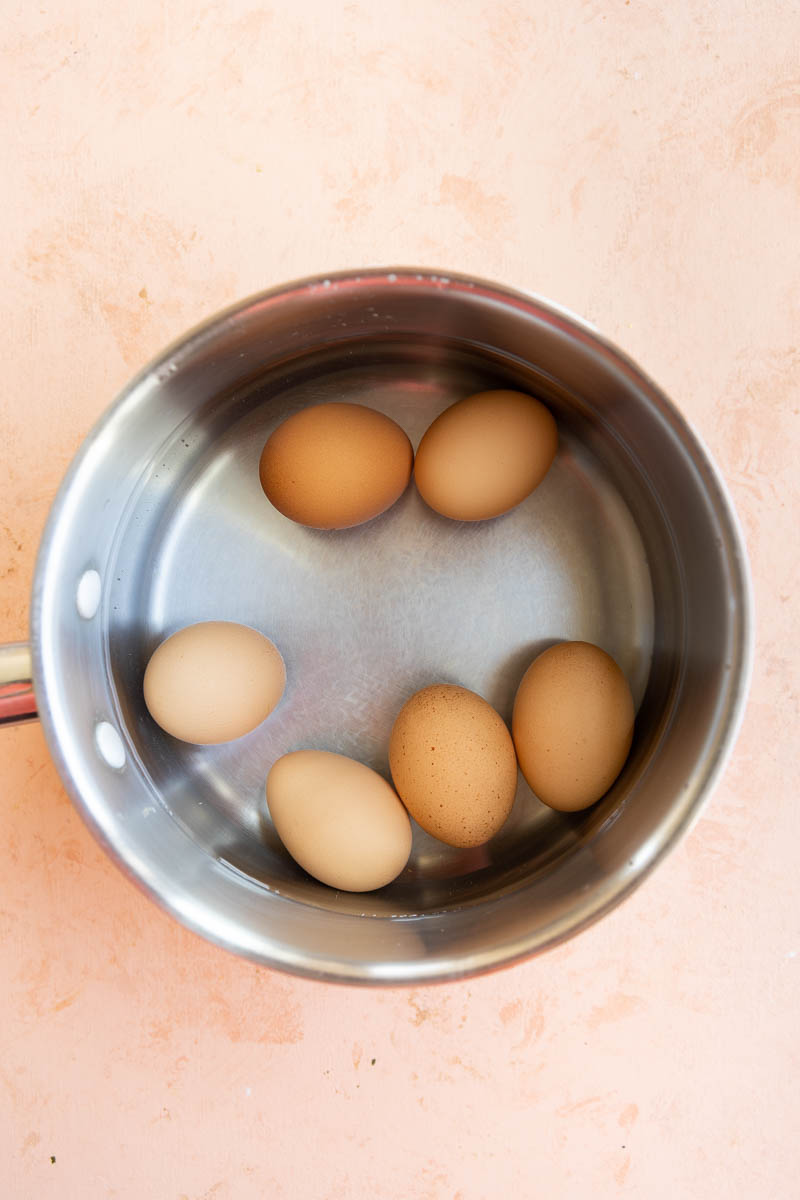 Eggs simmering in a pot.