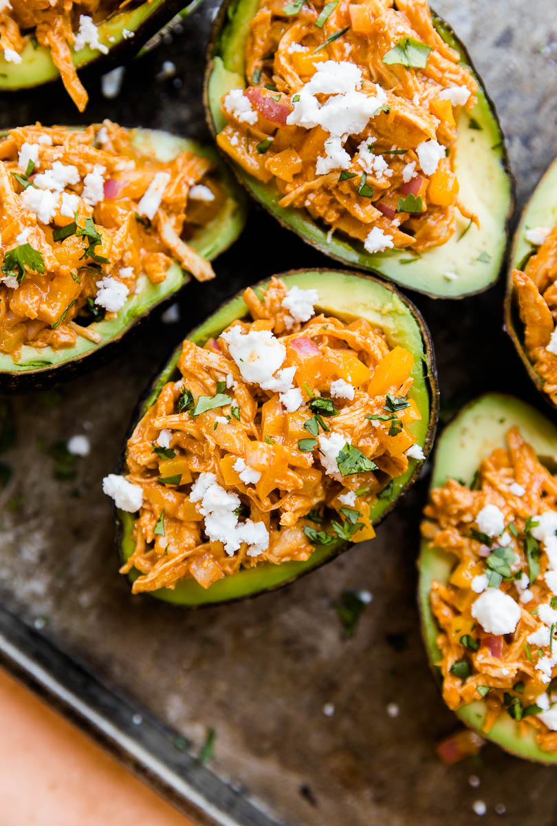 Avocado stuffed with buffalo chicken and topped with feta.