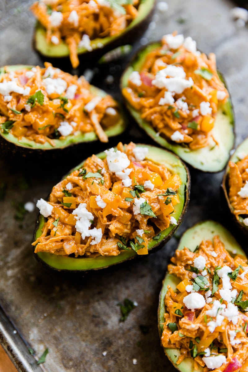 Buffalo chicken stuffed avocado with feta and chopped cilantro on top.