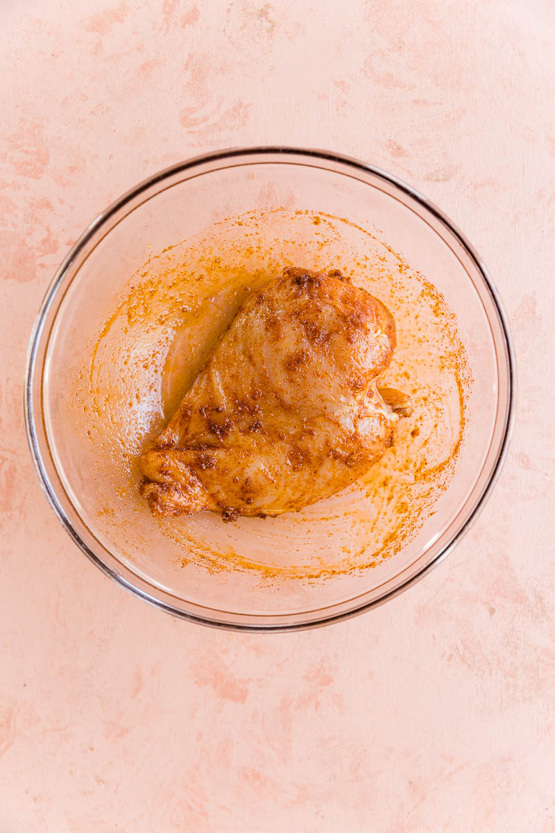 Chicken breast marinating in spices.