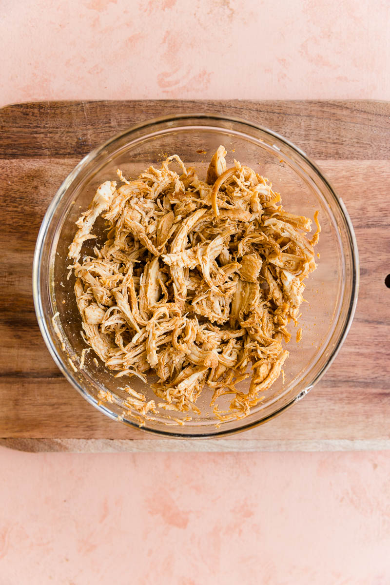 Shredded chicken in a glass bowl.