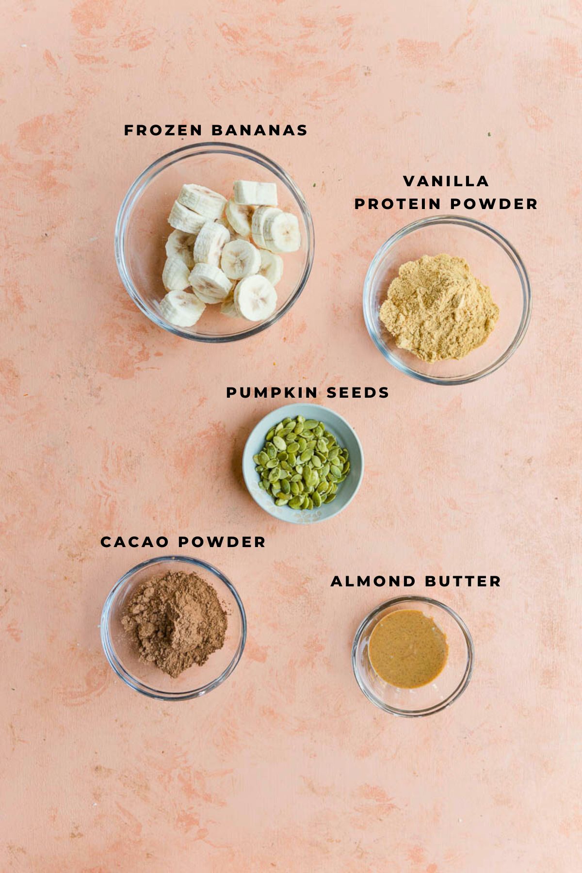 Chocolate banana protein shake ingredients measured out in small cups.