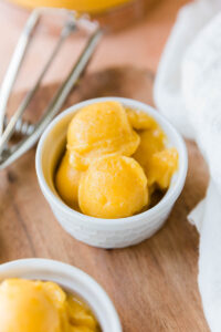 Peach sorbet in a white ceramic dish.