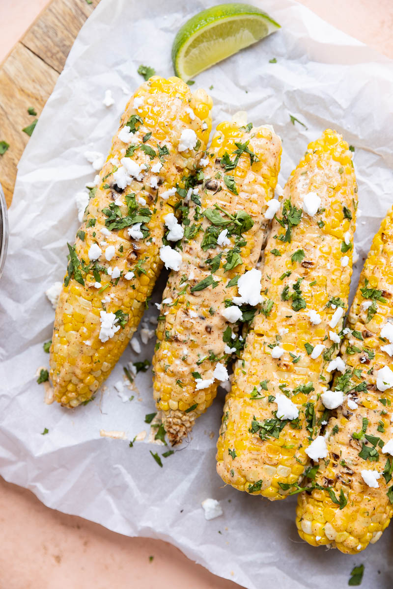 Mexican street corn with dairy free feta, cilantro, and fresh lime wedges.