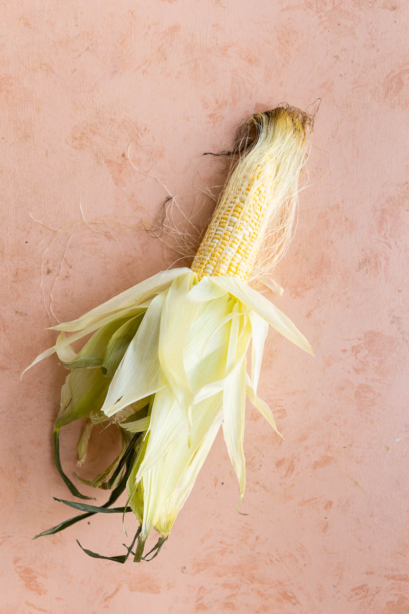 Peeled corn on the cobb with white fibers.