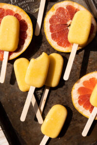 Orange popsicles on a baking sheet.