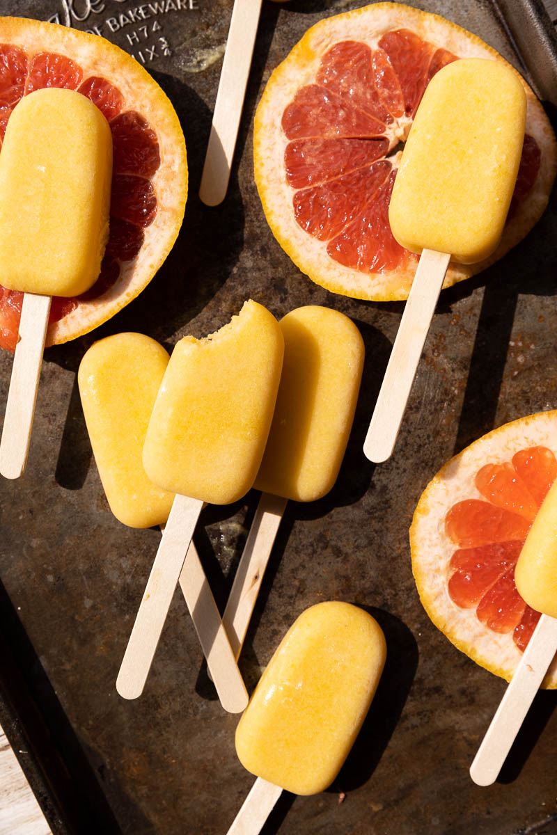 Orange popsicles on a baking sheet.