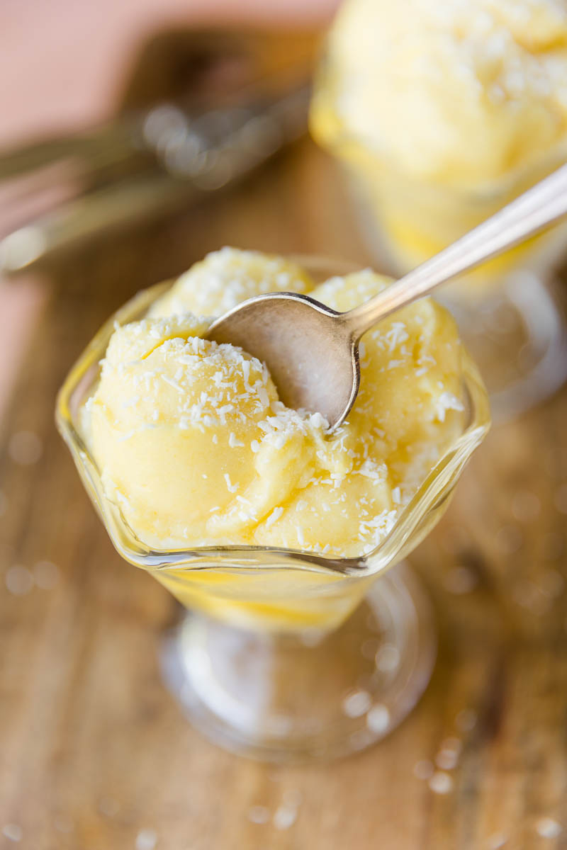 Spoon scooping out pineapple sorbet.
