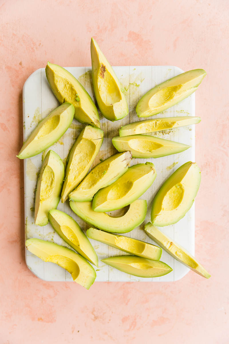 Avocado wedges on a cutting board.