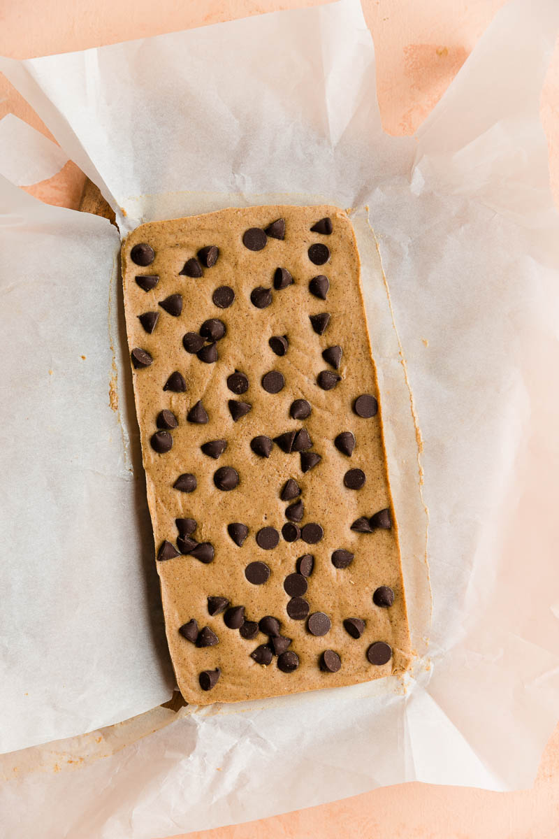 Chilled cookie dough protein bars on parchment paper.