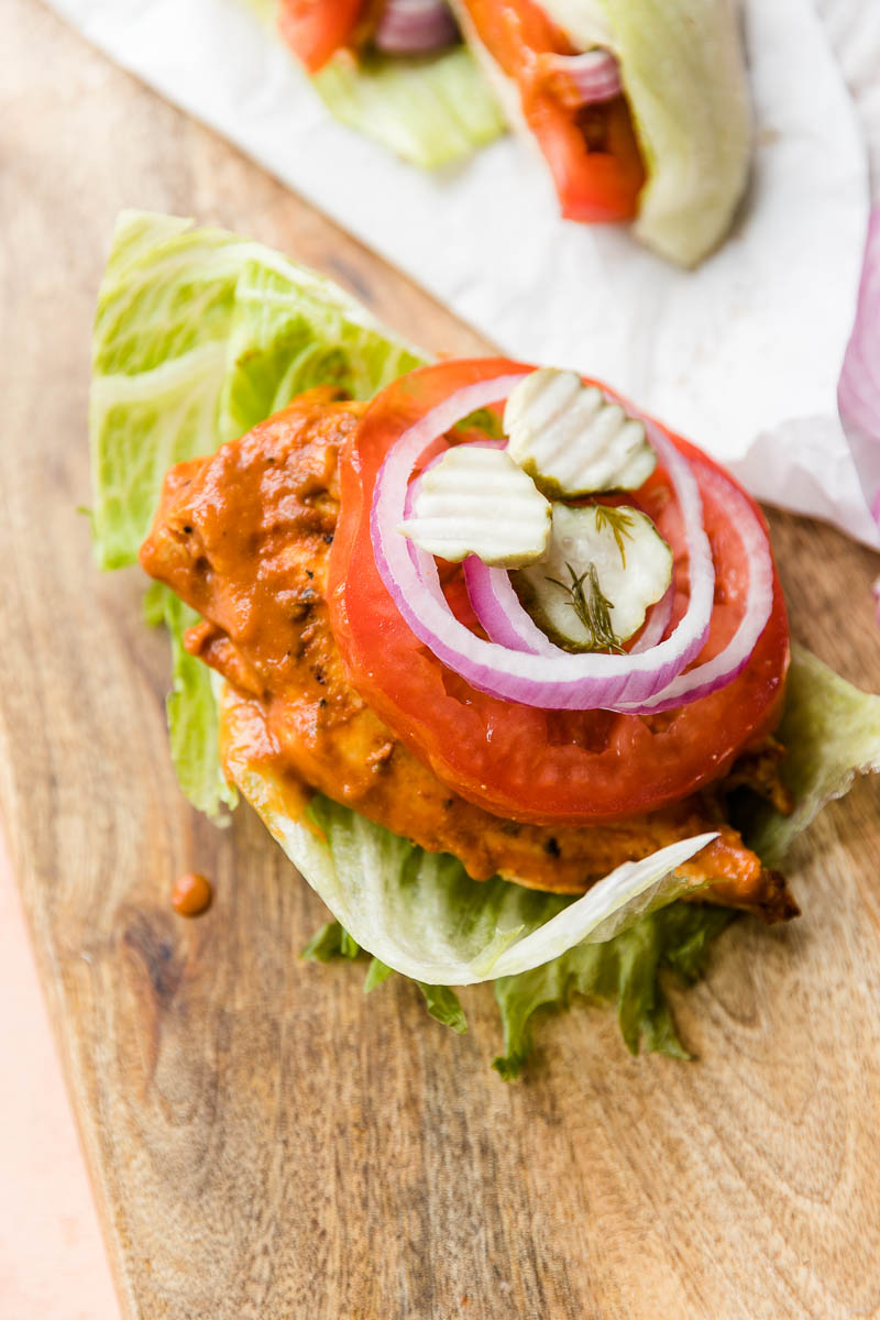 Chicken, lettuce, red onion, and pickles, on top of lettuce bun.