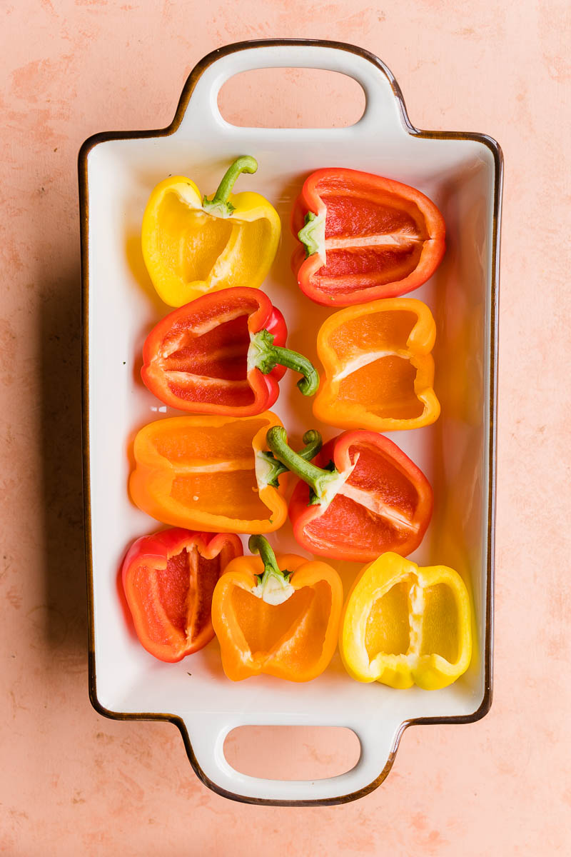 Peppers cut in half in a casserole dish.