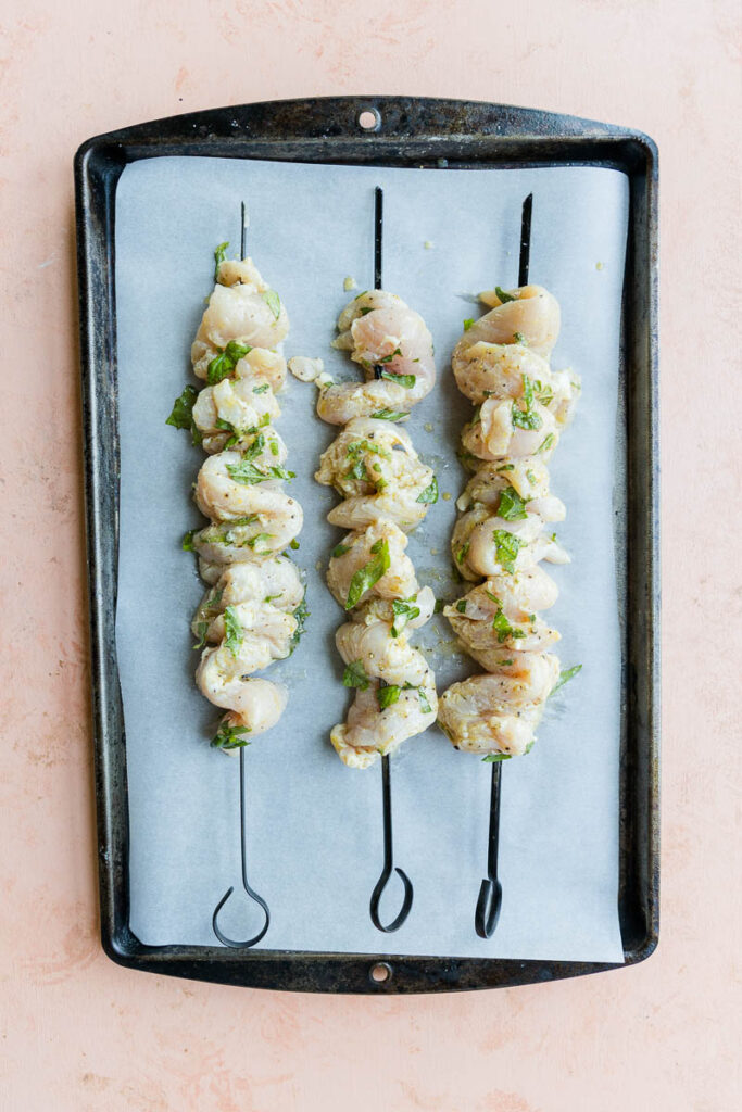 Marinated chicken on metal skewers.