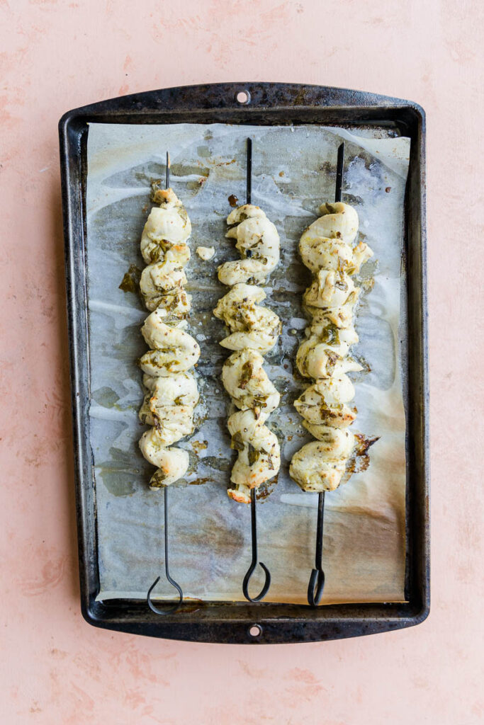 Baked lemon chicken on parchment paper lined baking sheet.