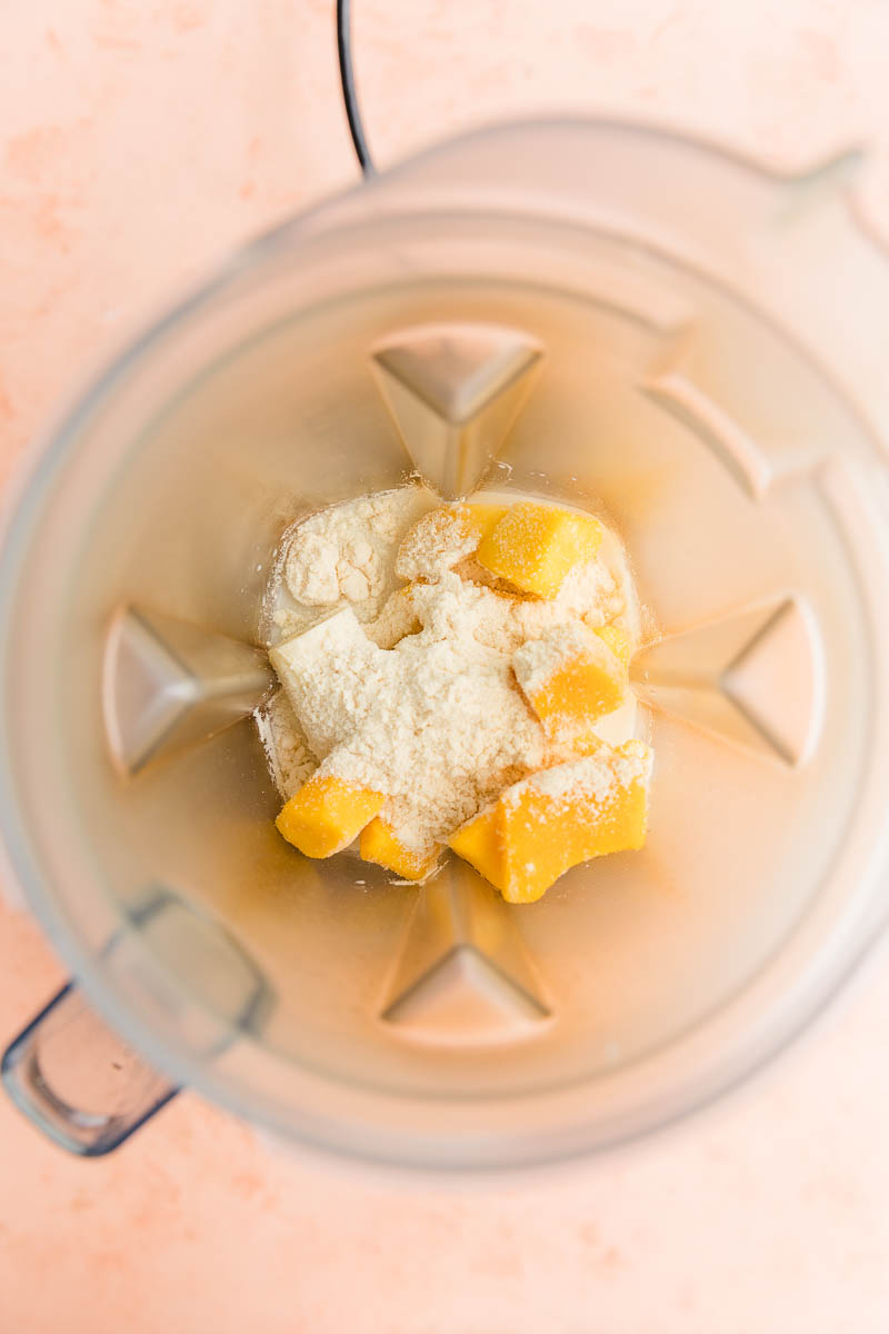 Mango smoothie ingredients in blender.