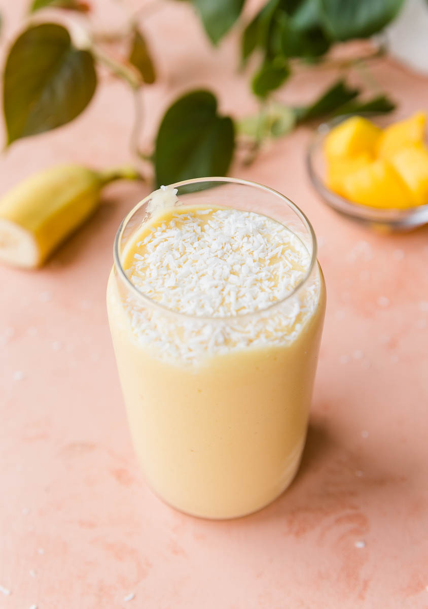 Mango protein shake with shredded coconut on top.