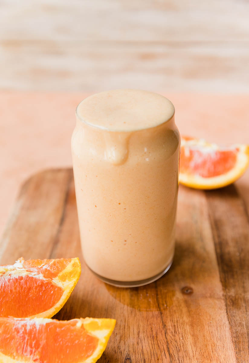 Orange smoothie dripping down glass.