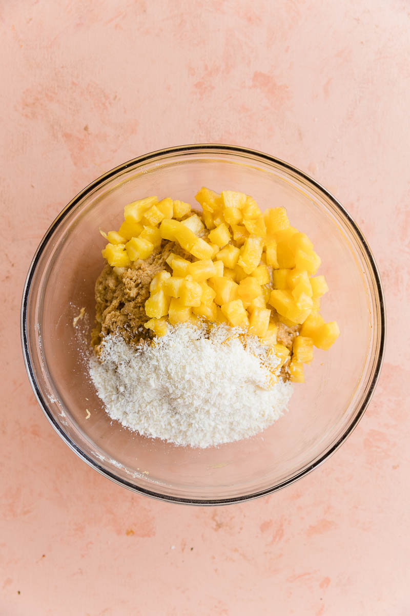 Bread batter with diced pineapple and shredded coconut on top.