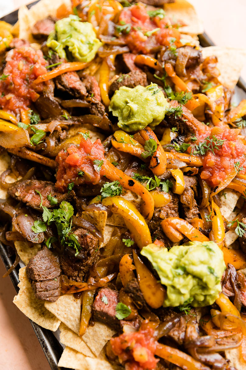 Steak fajita nachos on a large baking sheet.