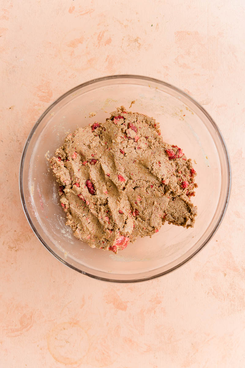 Strawberry protein bar mixture in a glass mixing bowl.