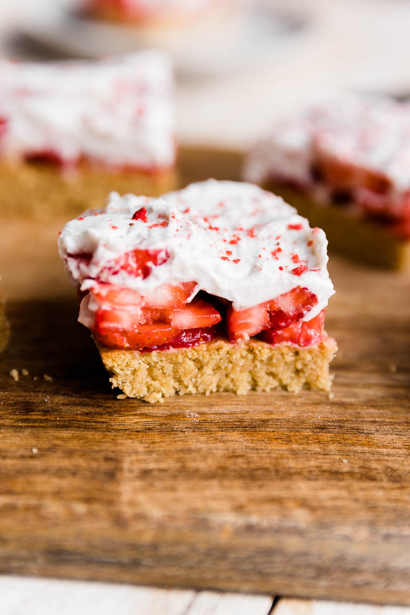 Strawberry shortcake bar with fresh whipped cream, strawberries, and shortbread crust.