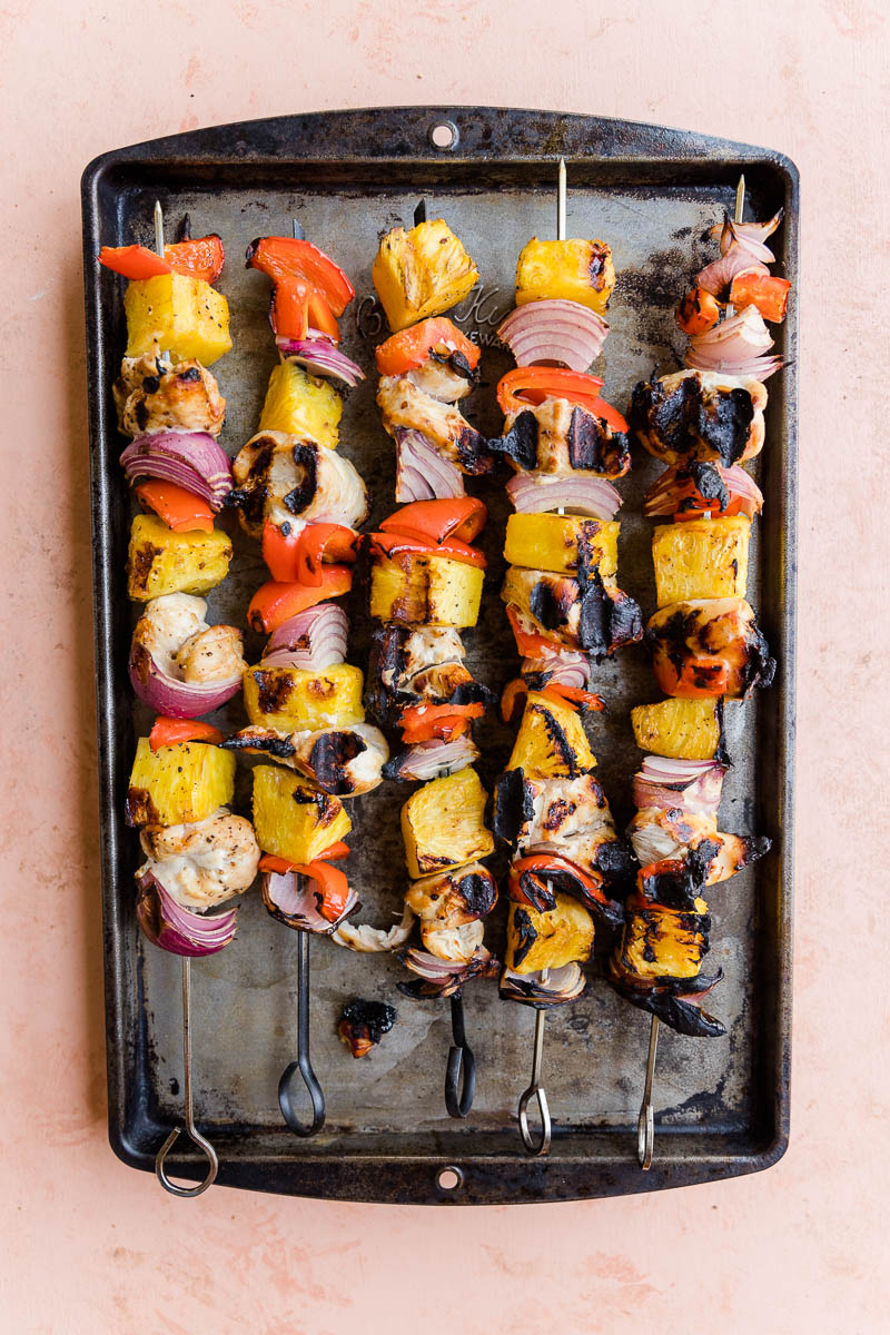 Grilled teriyaki chicken skewers on a baking sheet.