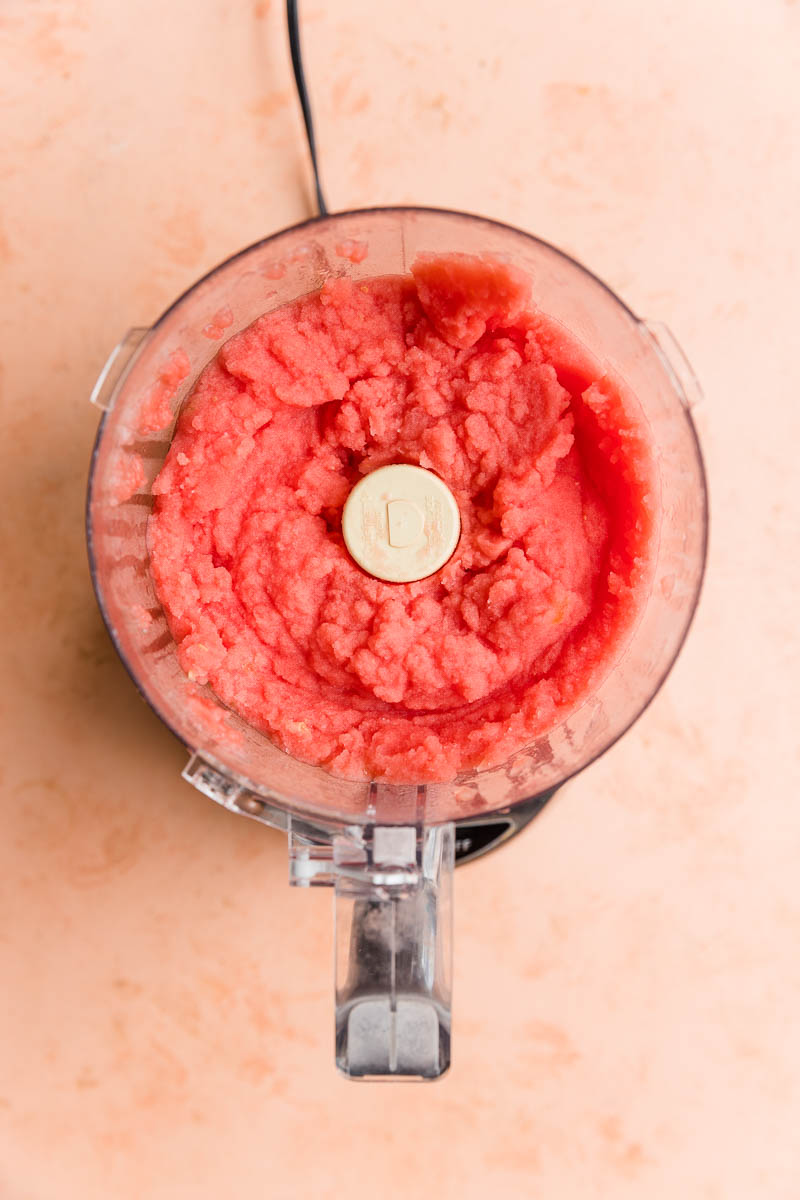 Creamy watermelon italian ice in a food processor.