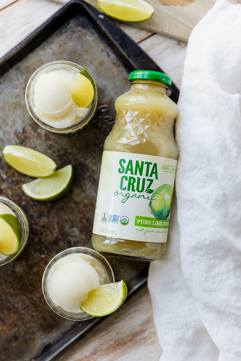 Santa cruz lime juice bottle next to cups of sorbet.