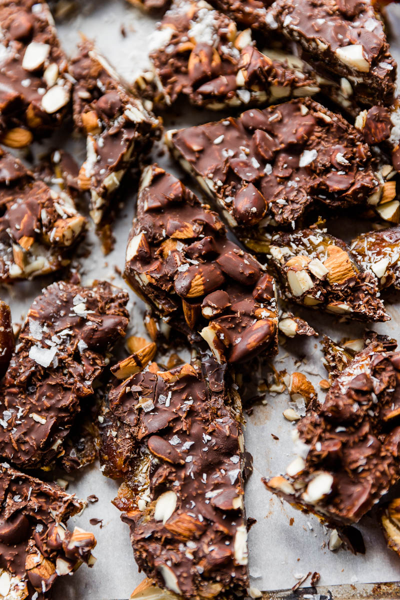 Almond joy date bark broken up on parchment paper.