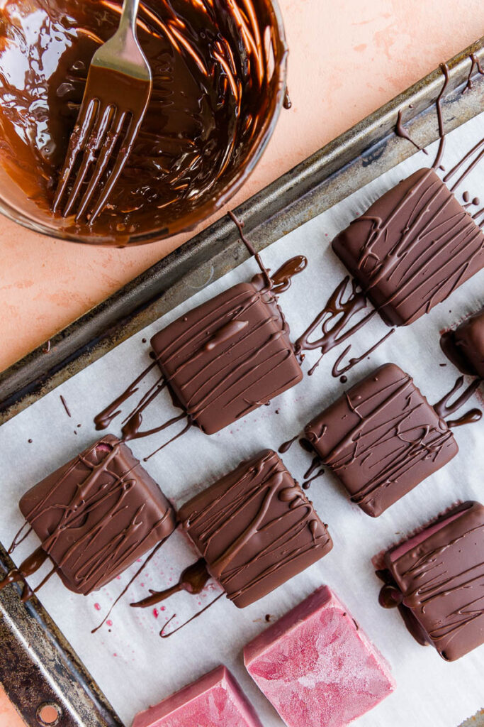 Chocolate covered ice cream bars with bowl of melted chocolate on the side.