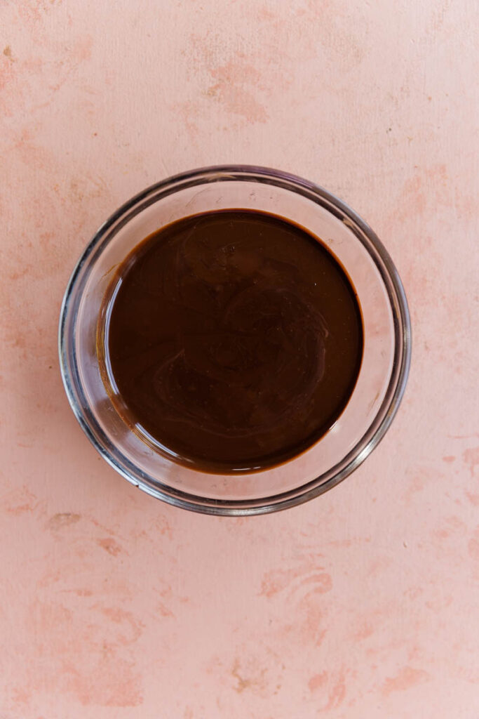 Melted chocolate in small glass bowl.