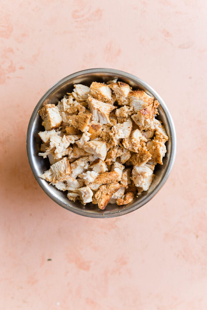 Cooked chicken cut into bite sized pieces in a bowl.