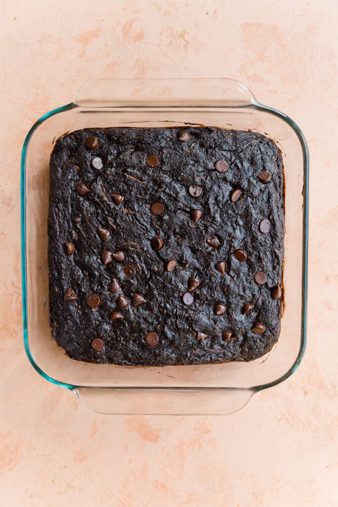 Baked chocolate zucchini brownies in a glass baking dish.