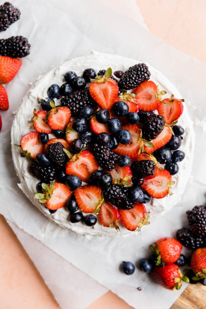 Cake frosted with fresh berries on top.