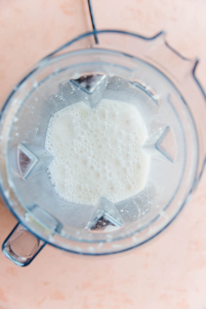 Frothy almond milk in blender.