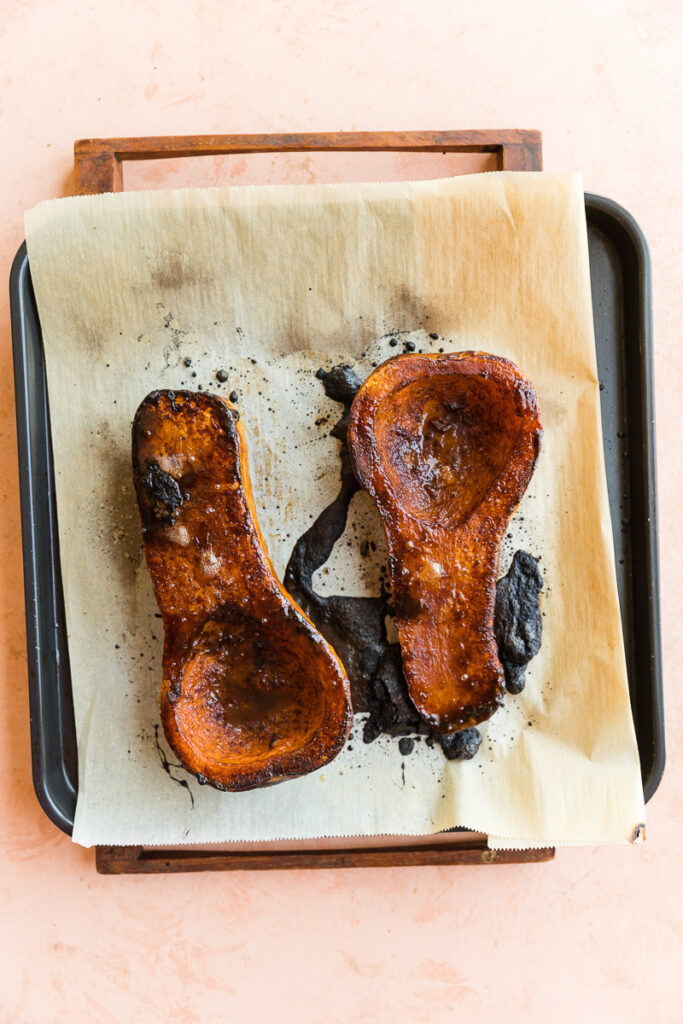 Crispy butternut squash halves on tray.