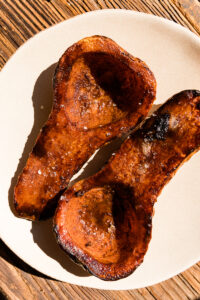 Butternut squash halves on a white plate.