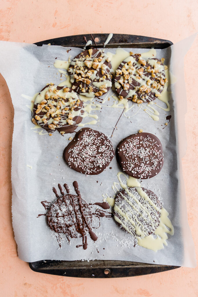 Chocolate covered apple slices with toppings.
