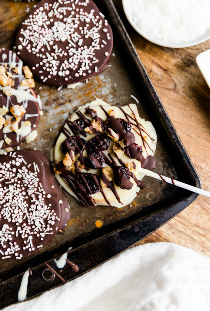 Chocolate covered apple pop with cranberries and walnuts.