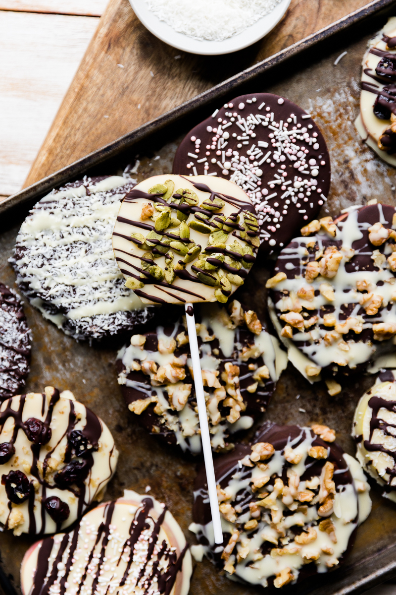 Chocolate covered apple pops on a baking sheet.